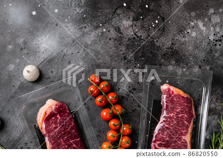New York steak in vacuum pack, on black dark stone table background, top view flat lay, with copy space for text New York steak in vacuum pack, on black dark stone table background, top view flat lay, with copy space for text 86820550