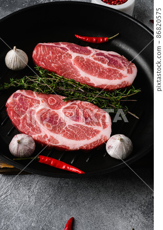 Slices pork loin with herbs, on gray stone table background Slices pork loin with herbs, on gray stone table background 86820575
