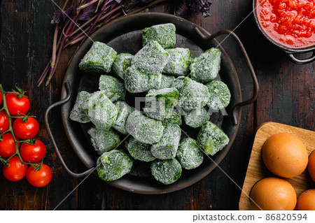 Frozen spinach blocks, on old dark wooden table background, top view flat lay Frozen spinach blocks, on old dark wooden table background, top view flat lay 86820594