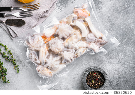 Frozen seafood set, squid rings, shrimp and octopus vacuum Packed, on gray stone table background, top view flat lay Frozen seafood set, squid rings, shrimp and octopus vacuum Packed, on gray stone table background, top view flat lay 86820630