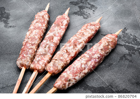 Raw Minced Lamb Shish Kebab kofta, on gray stone table background Raw Minced Lamb Shish Kebab kofta, on gray stone table background 86820704
