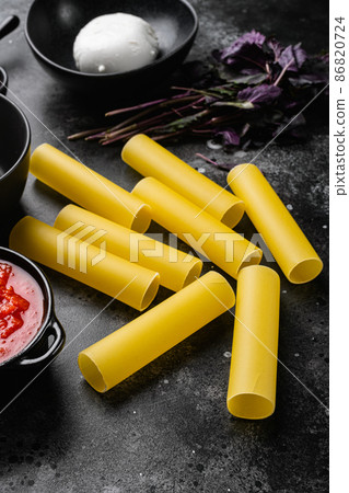 Cannelloni stuffed raw ingredients, on black dark stone table background 86820724