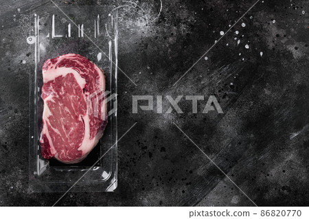 Vacuum plastic pack with fresh beef steak, on black dark stone table background, top view flat lay, with copy space for text Vacuum plastic pack with fresh beef steak, on black dark stone table background, top view flat lay, with copy space for text 86820770