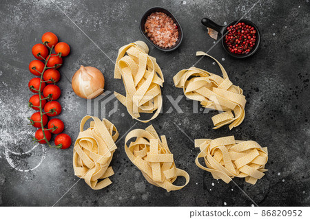 Raw pasta ingredient, on black dark stone table background, top view flat lay Raw pasta ingredient, on black dark stone table background, top view flat lay 86820952