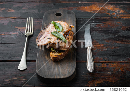 Liver bacon and onions on bread cooked meal served on board, over wooden background Liver bacon and onions on bread cooked meal served on board, over wooden background 86821062