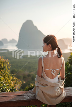 Happy traveler woman enjoy Phang Nga bay view point, alone Tourist sitting and relaxing at Samet Nang She, near Phuket in Southern Thailand. Southeast Asia travel, trip and summer vacation concept Happy traveler woman enjoy Phang Nga bay view point, alone Tourist sitting and relaxing at Samet Nang She, near Phuket in Southern Thailand. Southeast Asia travel, trip and summer vacation concept 86821302