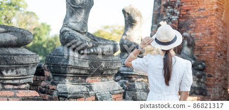Tourist Woman in white dress visiting to ancient stupa in Wat Chaiwatthanaram temple in Ayutthaya Historical Park, summer, Asia and Thailand travel concept 86821317