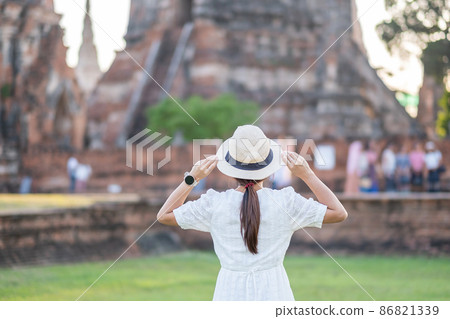 Tourist Woman in white dress visiting to ancient stupa in Wat Chaiwatthanaram temple in Ayutthaya Historical Park, summer, Asia and Thailand travel concept Tourist Woman in white dress visiting to ancient stupa in Wat Chaiwatthanaram temple in Ayutthaya Historical Park, summer, Asia and Thailand travel concept 86821339