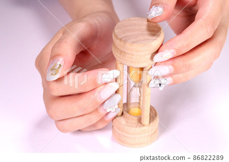 Female hand holding an hourglass 86822289