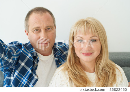 Self-portrait of mature couple in home interior on sofa. 86822460