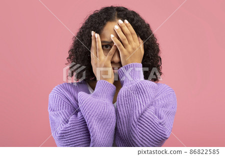 Shocked young black woman feeling frightened, covering face in fear on pink studio background 86822585