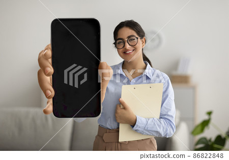 Attractive woman psychologist showing smartphone with empty screen Attractive woman psychologist showing smartphone with empty screen 86822848