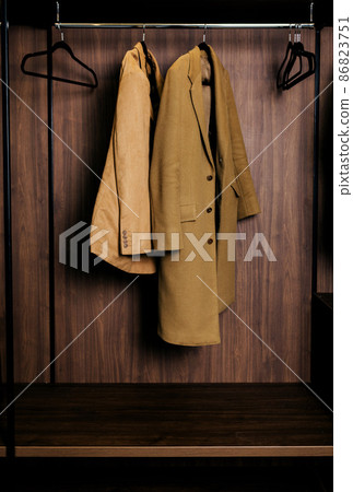 clothes hanging in wardrobe. clothes hanging in wardrobe. 86823751