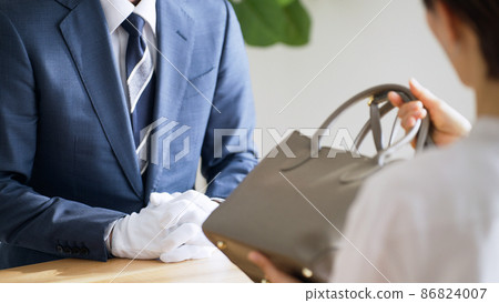 Appraisers and customers assessing bags 86824007