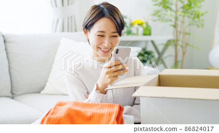 Smartphones, cardboard boxes, clothes, middle-aged women 86824017