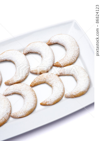 Traditional German or Austrian Vanillekipferl vanilla kipferl cookies on a plate isolated on white background Traditional German or Austrian Vanillekipferl vanilla kipferl cookies on a plate isolated on white background 86824123