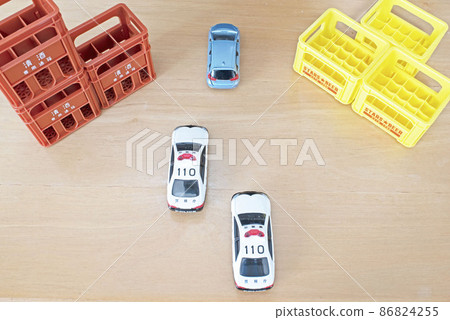 A passenger car chased by a box of sake and beer and two police cars A passenger car chased by a box of sake and beer and two police cars 86824255