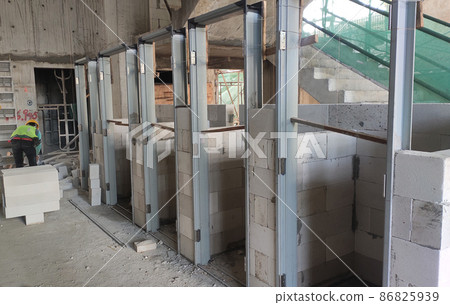 SEREMBAN, MALAYSIA -FEBRUARY 2, 2021: Blockwork by construction workers at the construction site. The bricks are stacked to form the walls as designed by the architect. SEREMBAN, MALAYSIA -FEBRUARY 2, 2021: Blockwork by construction workers at the construction site. The bricks are stacked to form the walls as designed by the architect. 86825939