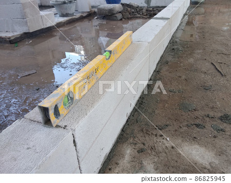 SEREMBAN, MALAYSIA -FEBRUARY 2, 2021: Blockwork by construction workers at the construction site. The bricks are stacked to form the walls as designed by the architect. SEREMBAN, MALAYSIA -FEBRUARY 2, 2021: Blockwork by construction workers at the construction site. The bricks are stacked to form the walls as designed by the architect. 86825945