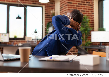 Entrepreneur sitting with hands over head to relax after finishing task in office 86827896