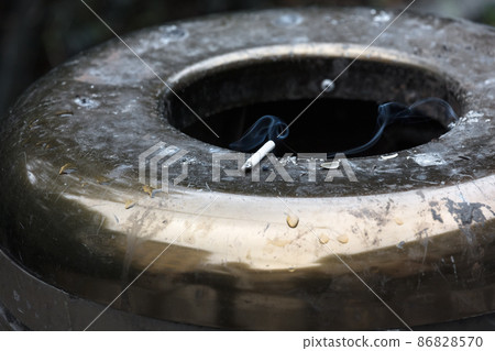 cigarette butt in trash can 86828570