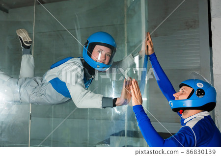 A man trains a woman as an astronaut. Classes on flying in a wind tunnel. A man trains a woman as an astronaut. Classes on flying in a wind tunnel. 86830139
