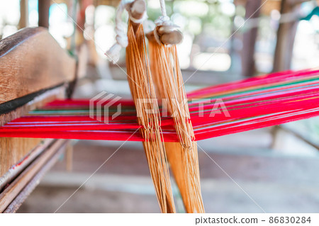 Thai and Asian Style Vintage textile thread machine to make traditional clothing and fabric pattern weaving. Thai and Asian Style Vintage textile thread machine to make traditional clothing and fabric pattern weaving. 86830284