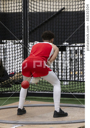 African American throwing the wieght at a track and field event 86830304