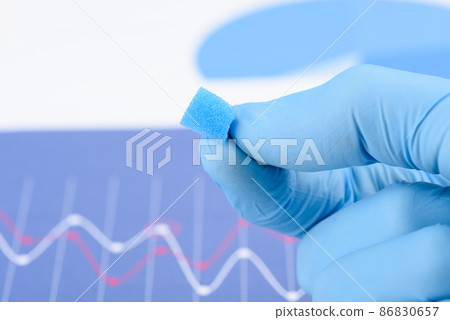 Blue porous foam material in scientist fingers in laboratory.  86830657