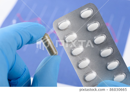 Scientist hold transparent capsule and blister pack. Medical treatment laboratory research Scientist hold transparent capsule and blister pack. Medical treatment laboratory research 86830665
