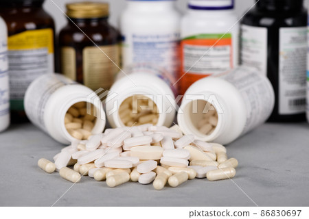 Bottles of vitamins and dietary supplements with pills on table 86830697