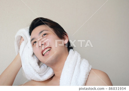 A man who dries his hair with a bath towel after taking a bath 86831934