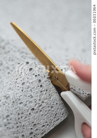 Female hand cutting the old shii mat with scissors 86831964