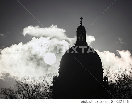 Profile of the dome St. Isaac's Cathedral against the background of cloud of frosty fog illuminated by the low winter sun. 86832106