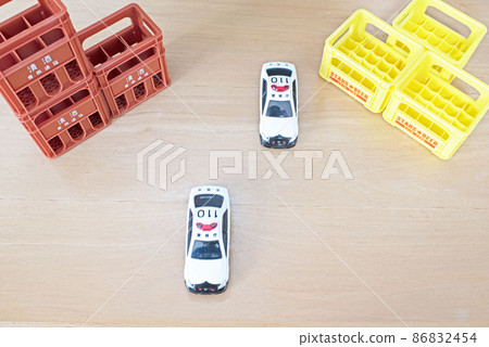 Two police cars running side by side with a box of sake and beer 86832454