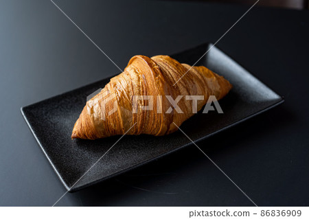 Croissant and a cup of tea on a neutral background selective focus 86836909