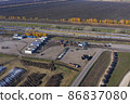 Reception of sugar beets at a sugar factory. The queue of trucks at the reception of beets at the factory. Aerial shooting. 86837080