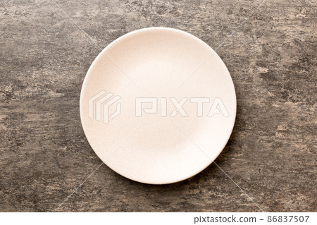 Top view of empty colorful plate on cement background. Empty space for your design Top view of empty colorful plate on cement background. Empty space for your design 86837507
