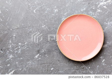 Top view of empty pink plate on cement background. Empty space for your design Top view of empty pink plate on cement background. Empty space for your design 86837528