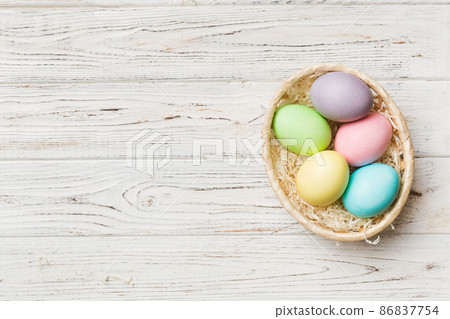 Multi colors Easter eggs in the woven basket on colored background . Pastel color Easter eggs. holiday concept with copy space Multi colors Easter eggs in the woven basket on colored background . Pastel color Easter eggs. holiday concept with copy space 86837754