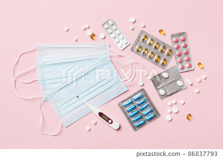 Protective face masks or surgical masks, medicine pills and thermometer on table background. Coronavirus disease. Corona virus concept. Space for text 86837793