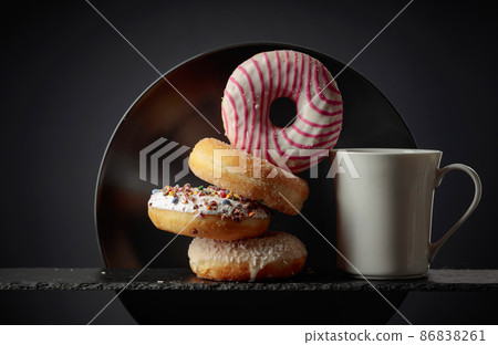 Sweet delicious tasty donuts and a white mug. Sweet delicious tasty donuts and a white mug. 86838261