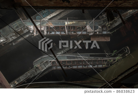 Damaged escalators in abandoned shopping mall building. Damaged escalators in abandoned shopping mall building. 86838623