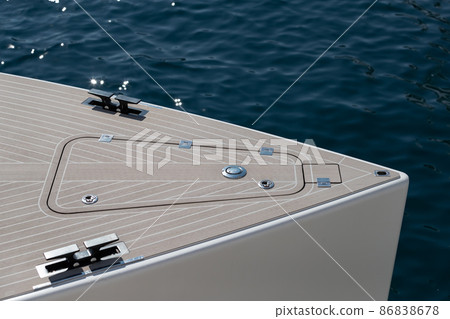 Close up view of front part of the boat at sunny day, bow of the boat, forepeak, hooks for a cable, the wooden deck, white color Close up view of front part of the boat at sunny day, bow of the boat, forepeak, hooks for a cable, the wooden deck, white color 86838678