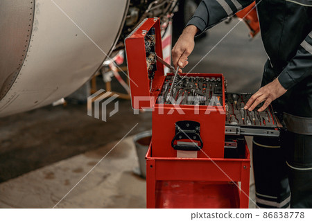 Male mechanic using instrument box in hangar 86838778