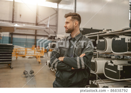 Bearded man airplane mechanic standing in hangar Bearded man airplane mechanic standing in hangar 86838792