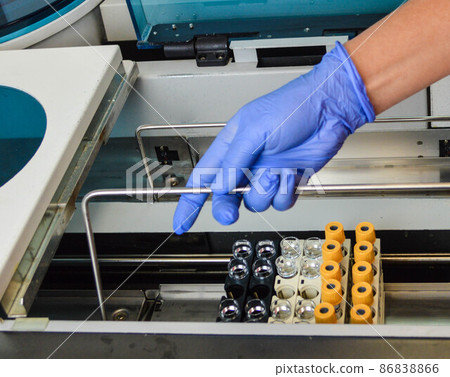 a doctor of laboratory diagnostics puts test tubes with multi-colored caps into the analyzer to perform laboratory tests. health diagnostics with the help of tests a doctor of laboratory diagnostics puts test tubes with multi-colored caps into the analyzer to perform laboratory tests. health diagnostics with the help of tests 86838866