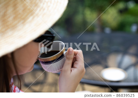 Close-up view of a girl drinking her morning coffee from a cup. Close-up view of a girl drinking her morning coffee from a cup. 86839525