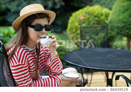 Close-up view of a girl drinking her morning coffee from a cup. 86839529