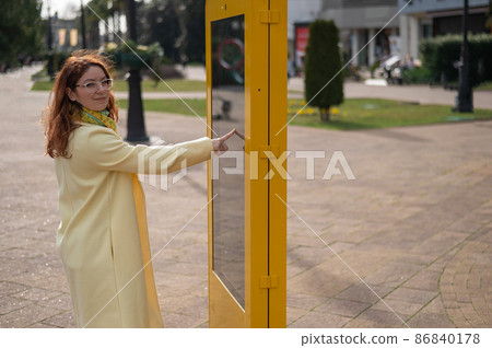 Caucasian woman using touch information board outdoors.  86840178